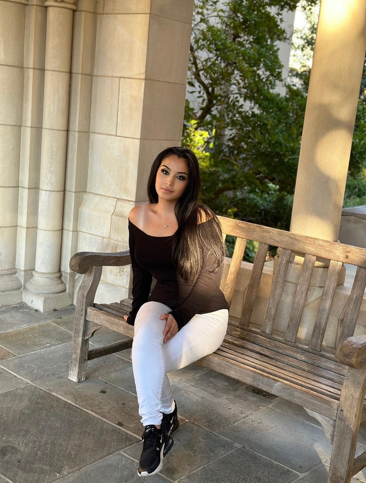 Camelia, photographed in an off-shoulder top against a colonnade.